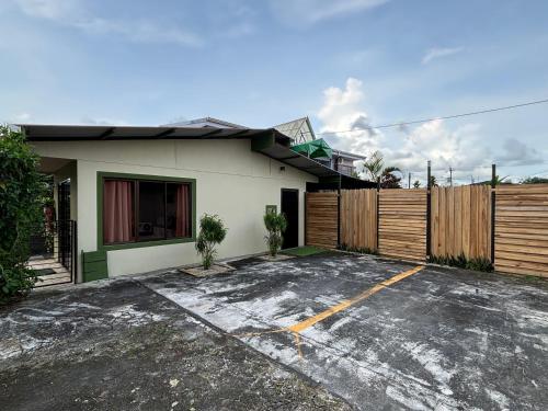 a white house with a fence and a parking lot at Arenal Thiago with Private Jacuzzi in Fortuna