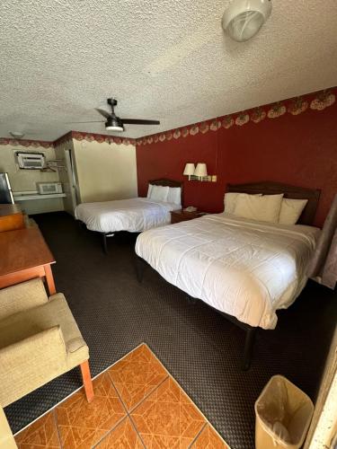 two beds in a room with red walls at Hico Hills Inn in Hico