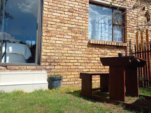 a birdbath in front of a brick building at Inni Bush Guesthouse in Noordheuwel