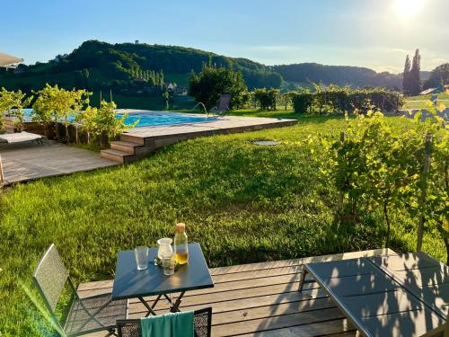 a table on a deck with a view of a yard at An der Lage - Exklusives Apartment mit Toskana Flair in Obegg