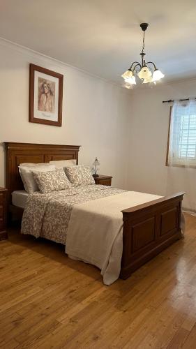 a bedroom with a large bed and a chandelier at Appartement tout confort Valpaços 2 in Valpaços