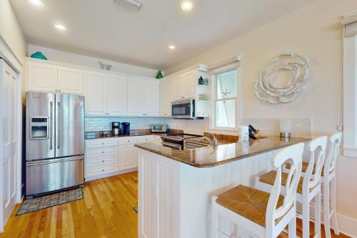 a kitchen with white cabinets and a stainless steel refrigerator at Deja Vu at Carillon in Carillon Beach