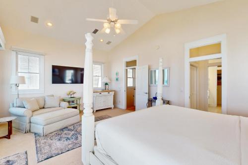 a white bedroom with a bed and a couch at Deja Vu at Carillon in Carillon Beach