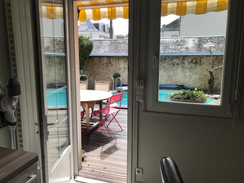 - une porte donnant sur une terrasse avec vue sur la piscine dans l'établissement Maison centre ville piscine calme confort, à Blois