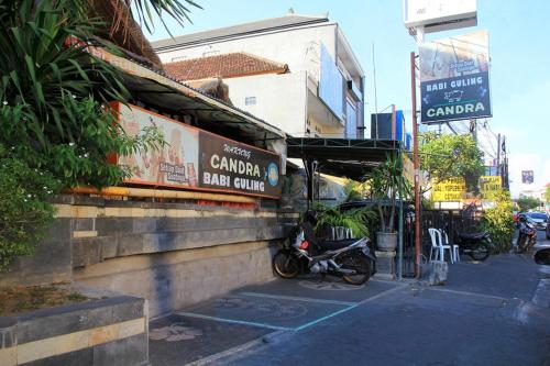 a motorcycle parked in front of a bar called caruana bar council at Choice Stay Hotel Denpasar in Denpasar