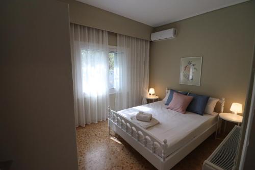 a bedroom with a bed and a window at Lia Beach house near airport in Artemida