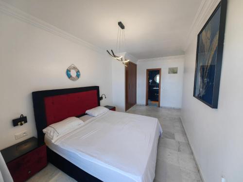 a bedroom with a large white bed with a red headboard at City Bleu Maroc in Tangier