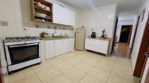 a kitchen with a stove and a refrigerator at House Temporada in Búzios