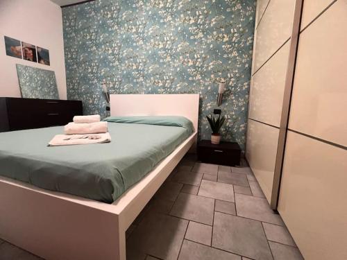 a bedroom with a bed and a wall with flowers at Il Cortiletto di Varese in Varese