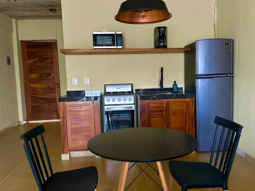 a small kitchen with a table and a refrigerator at Lolitas Suites 304 in Zihuatanejo