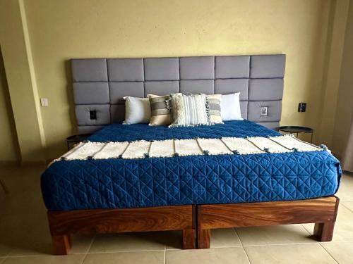 a large bed with a blue comforter and pillows at Lolitas Suites 304 in Zihuatanejo