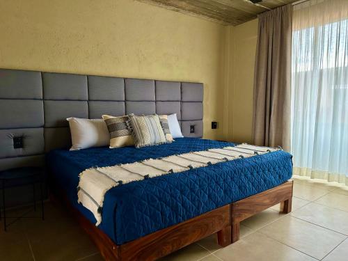 a bedroom with a large blue bed with pillows at Lolitas Suites 304 in Zihuatanejo