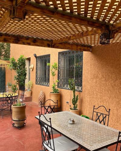 a patio with a table and chairs on a patio at Miguirne Chez Ali in Tamellalt