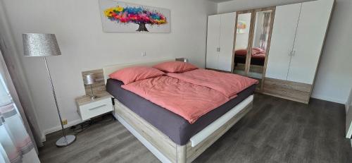a bedroom with a bed with pink sheets and a mirror at Ferienwohnung in Neuss nahe Düsseldorf in Hamm
