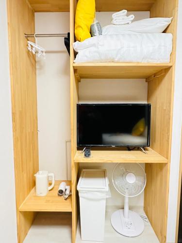 a room with a bunk bed with a tv and a desk at home鶴見橋 in Osaka