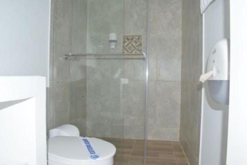 a bathroom with a toilet and a glass shower at Hotel Parque de los Arrieros in Montenegro