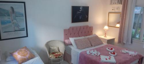 a bedroom with a pink bed and a chair at Atlântico Hotel in Rio das Ostras