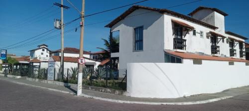 a white house on the side of a street at Atlântico Hotel in Rio das Ostras
