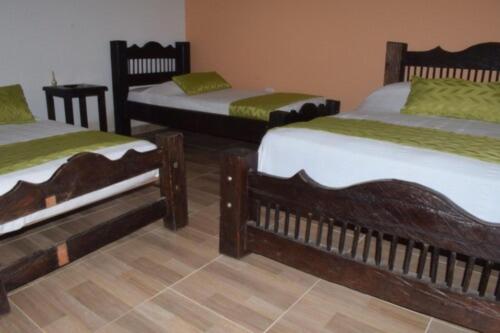 a group of three beds in a room at Hotel Parque de los Arrieros in Montenegro