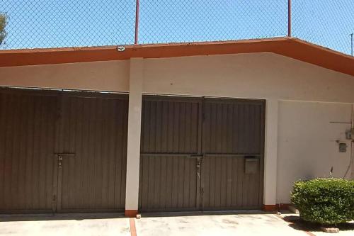 a garage with three garage doors on a building at Rumbos Turísticos - casa hasta para 15 personas in Tulancingo