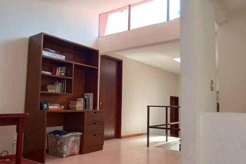 a room with a book shelf and a staircase at Rumbos Turísticos - casa hasta para 15 personas in Tulancingo