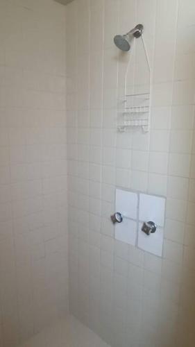 a white tiled shower with a shower head in a bathroom at Rumbos Turísticos - casa hasta para 15 personas in Tulancingo