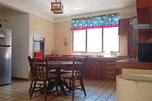 a kitchen with a table and chairs and a refrigerator at Rumbos Turísticos - casa hasta para 15 personas in Tulancingo