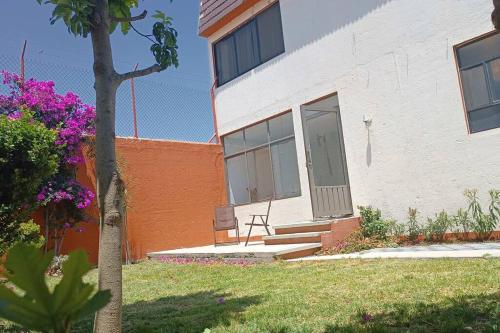 a building with a door and a bench in a yard at Rumbos Turísticos - casa hasta para 15 personas in Tulancingo