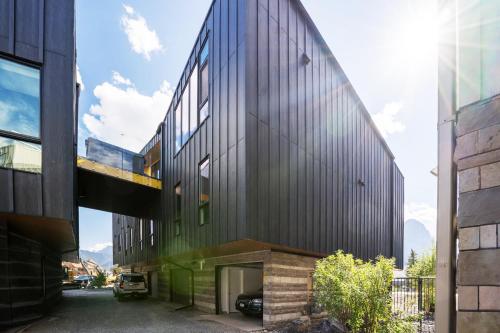 a building with a black facade with a garage at Raven's Peak 105 - Ultra luxe Mountain Retreat in Canmore