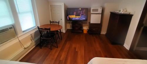 a room with a table and a television in a room at Cappuccio Hotel in Keansburg
