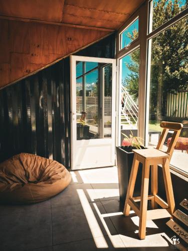 a room with a wooden chair and a wooden door at Dormís Acá in Esquel