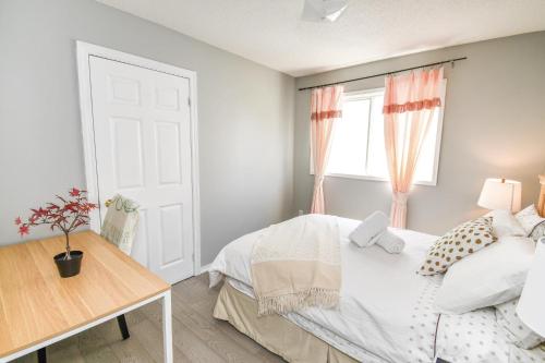 a bedroom with a bed and a table and a window at Lake Simcoe 4 Bedroom Family Home Ideal Toronto Area Retreat in Innisfil