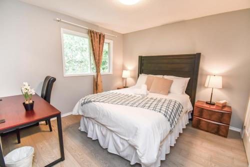 a bedroom with a bed and a desk and a window at Lake Simcoe 4 Bedroom Family Home Ideal Toronto Area Retreat in Innisfil