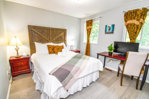 a bedroom with a bed and a desk and a computer at Lake Simcoe 4 Bedroom Family Home Ideal Toronto Area Retreat in Innisfil