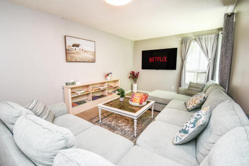 a living room with a couch and a table at Lake Simcoe 4 Bedroom Family Home Ideal Toronto Area Retreat in Innisfil