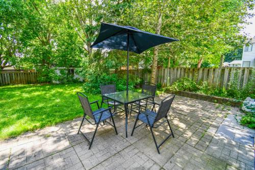a table and chairs with an umbrella on a patio at Lake Simcoe 4 Bedroom Family Home Ideal Toronto Area Retreat in Innisfil