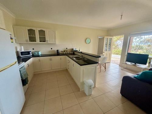 a kitchen with white cabinets and a counter top at Sea Valley Views in Port Lincoln