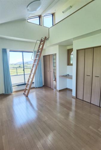 a ladder in a room with a living room at リニューアル 高島市風車村琵琶湖畔別荘サウナ付きファミリーグループ大歓迎テラス炭火BBQ Reiwa House in Takashima