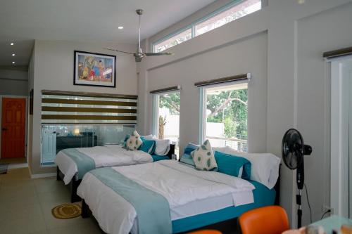 a bedroom with two beds and a fireplace at Casa de Simone BAGAC in Bagac