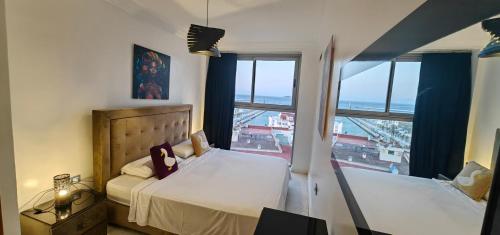 a bedroom with two beds and a large window at City Bleu Maroc in Tangier
