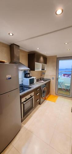 a large kitchen with a refrigerator and a window at City Bleu Maroc in Tangier