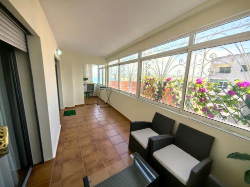 a waiting room with a couch and two windows at City Bleu Maroc in Tangier