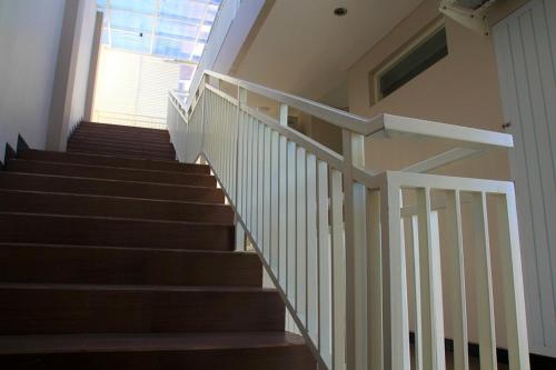 a set of stairs with a white railing in a building at Choice Stay Hotel Denpasar in Denpasar