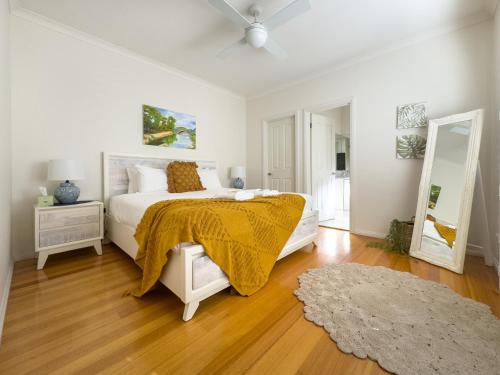 Un dormitorio blanco con una cama y un espejo. en Views On Montpellier, en Healesville