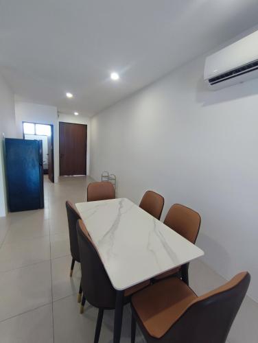 a dining room with a white table and chairs at Kuching Near GalaCity Armadale Residence Apartment in Kampong Tabuan