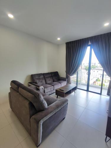 a living room with a couch and a table at Kuching Near GalaCity Armadale Residence Apartment in Kampong Tabuan