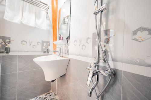 a white bathroom with a sink and a shower at Cat Ba Madame Duyen Hotel in Cat Ba