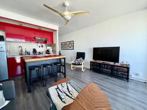 un salon avec une cuisine dotée de placards rouges dans l'établissement T2 à Saint-Cyprien, proche port, parking inclus - FR-1-309-480, à Saint-Cyprien
