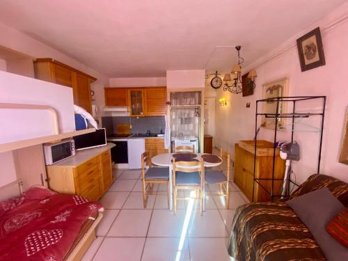 une cuisine avec une table et des chaises dans une pièce dans l'établissement Studio cabine 20m², 4 pers, proche commerces, balcon, parking - FR-1-758-32, aux Angles