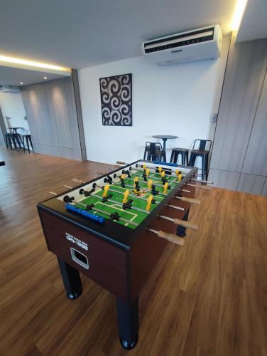 a large foosball table in a room with chairs at Kuching Near GalaCity Armadale Residence Apartment in Kampong Tabuan
